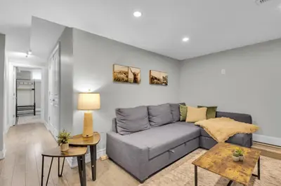 a living room with a gray couch and a table at 6BR house near Shops, Transit, Hwy and GO in Mississauga