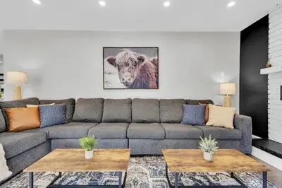 a living room with a couch and a cow picture at 6BR house near Shops, Transit, Hwy and GO in Mississauga