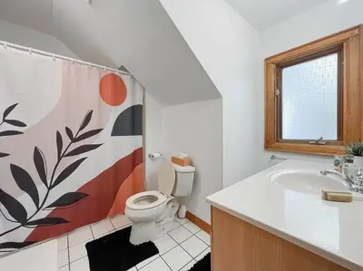 a bathroom with a toilet and a sink and a window at Luxury Hillside Farmhouse on The Bay of Quinte in Belleville