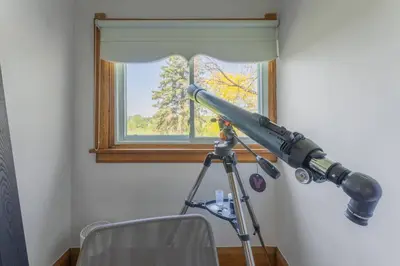 a telescope in a room with a window at Luxury Hillside Farmhouse on The Bay of Quinte in Belleville