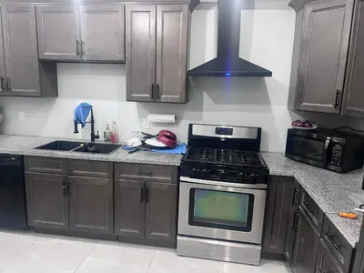 a kitchen with wooden cabinets and a stove top oven at Bb11 Private Bathroom Room In Cambridge in Cambridge