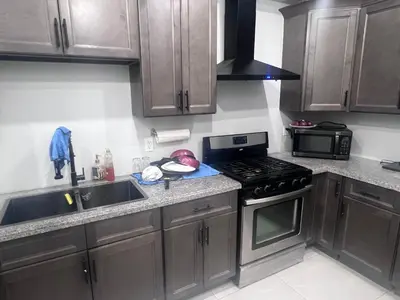 a kitchen with wooden cabinets and a stove top oven at Private Room In Cambridge B4 in Cambridge