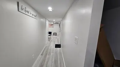 a hallway with white walls and a long hallway with at Garden Ave Home 1mins to HWY 403 in Brantford