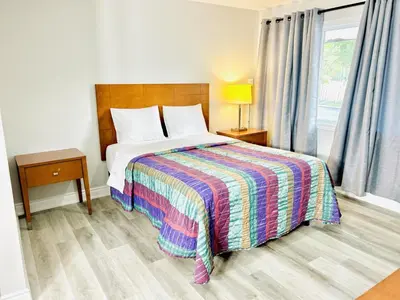 a bedroom with a bed with a colorful blanket at Brant Inn in Brantford