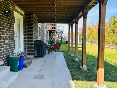 a covered porch of a house with a table and chairs at Rita's Kunjo - 2BR, 3BD, 2WR, Full Ktchn, Living in Whitby
