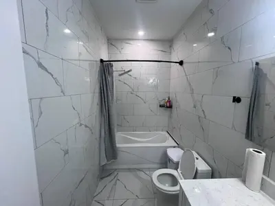 a white bathroom with a toilet and a bath tub at B12 Private Room In Cambridge in Cambridge