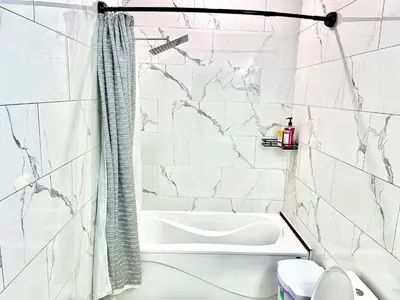 a bathroom with a white tub and marble walls at Private Room In Cambridge B8DW in Cambridge
