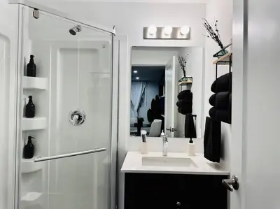 a white bathroom with a sink and a shower at Luxury Stay Near Niagara Falls in Niagara Falls