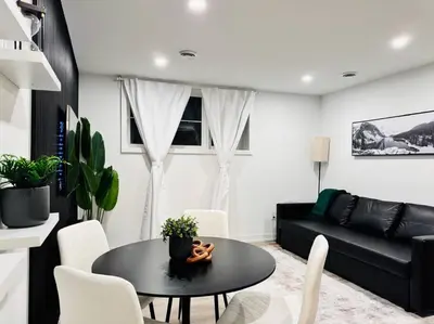 a living room with a table and a black couch at Luxury Stay Near Niagara Falls in Niagara Falls