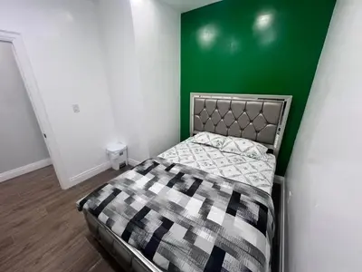 a bed in a room with a green wall at Private Bathroom Room In Cambridge B7 in Cambridge