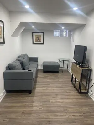 a living room with a couch and a tv at 2 Bedroom Guest Apartment with Separate Entrance in Brampton