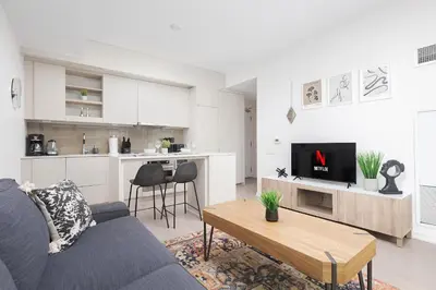 a living room with a blue couch and a kitchen at 1BR Space - Downtown Toronto in Toronto