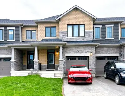 a red car parked in front of a house at New 3-BR Home Near Niagara Falls with King Bed 75 Inch TV and Free Parking in Thorold