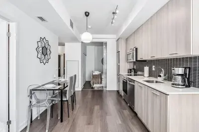 a kitchen with a table and a dining room at Stylish 2BR Urban Escape, BBQ, Private Terrace in Toronto