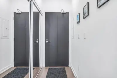 a hallway with two gray doors and a mirror at Stylish 2BR Urban Escape, BBQ, Private Terrace in Toronto