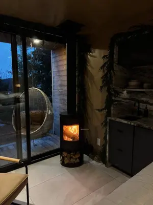 a fireplace in a room with a view of a patio at Aux Box Muskoka Modern Muskoka Bunkie in Huntsville