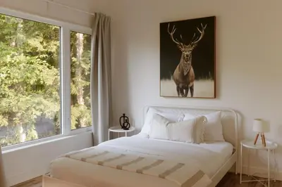 a bedroom with a bed and a picture of a deer at Wolegib Waterfront Retreat in Muskoka in Huntsville