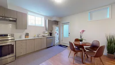 a kitchen with a table and chairs in a room at New Custom-built House Close to Rogers Stadium in Toronto