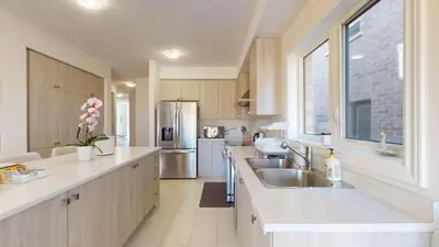a kitchen with a sink and a refrigerator at New Custom-built House Close to Rogers Stadium in Toronto