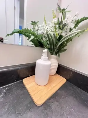 a bottle of soap and a vase of flowers on a table at Brand New Luxurious 4B Townhouse in Oshawa