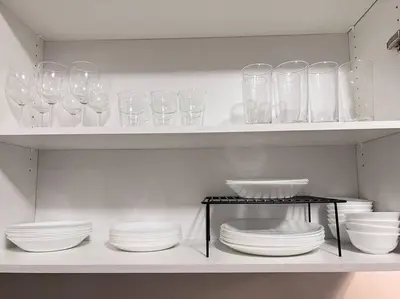 a shelf filled with glasses and plates and bowls at Brand New Luxurious 4B Townhouse in Oshawa