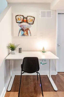 a white desk with a chair and a painting at 2 bedroom apartment-2 free parking -14 min to Pearson airport in Mississauga