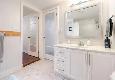 a white bathroom with a sink and a mirror at 2 bedroom apartment-2 free parking -14 min to Pearson airport in Mississauga
