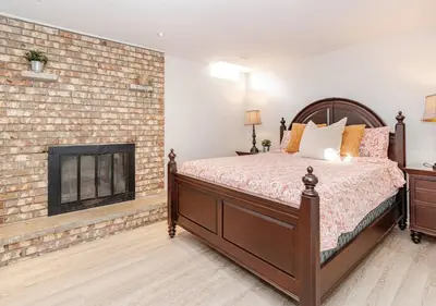a bedroom with a bed and a brick fireplace at 2 bedroom apartment-2 free parking -14 min to Pearson airport in Mississauga