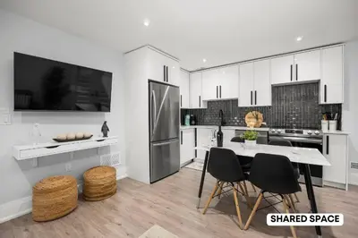 a kitchen with white cabinets and a table and chairs at Modern Master Suite Private Ensuite 29 Nights in Toronto