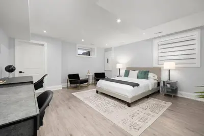 a white bedroom with a bed and a desk at Modern Master Suite Private Ensuite 29 Nights in Toronto