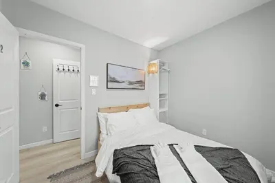 a white bedroom with a bed and a hallway at Private Cozy Room with Free Parking in Toronto