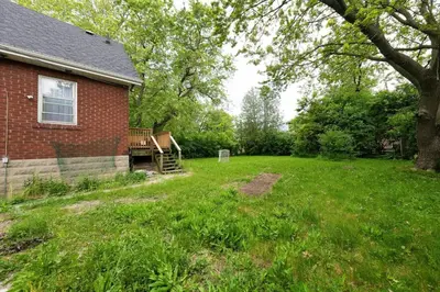 an empty yard next to a house with a tree at Private Cozy Room with Free Parking in Toronto