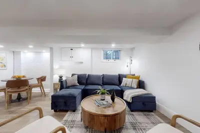 a living room with a blue couch and a table at Fresh and Modern Guest Suite in Toronto
