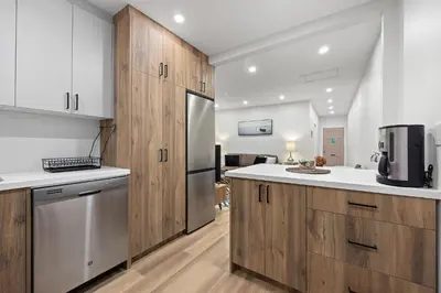 a kitchen with wooden cabinets and a stainless steel refrigerator at Private House with parking & steps to subway in Toronto