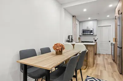 a kitchen and dining room with a wooden table and chairs at Private House with parking & steps to subway in Toronto