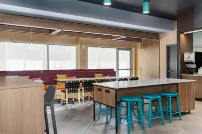 a cafeteria with tables and stools at Tru By Hilton Bracebridge, On in Bracebridge