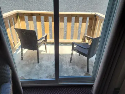 a view of a chair and a chair outside a window at Sand Castle Suites Motel in Port Elgin