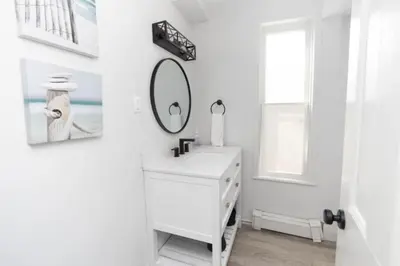 a white bathroom with a sink and a mirror at County Cove - Wellington Suite - Two-Bedroom Wellington Apartment in Wellington