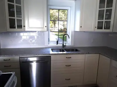 a white kitchen with a sink and a window at Sakura Cottage - Serenity on PEC Waterfront in Wellington