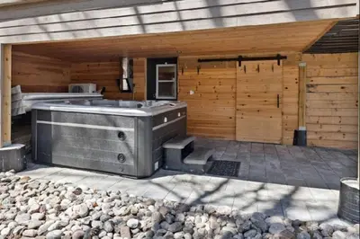 a outdoor hot tub in a backyard with a wooden wall at Muskoka Charm Beautiful four bedroom cottage in Gravenhurst