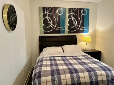 a bedroom with a bed with a checkered blanket at Comfy 1Bdrm den 2Baths with 3 real beds plus parking in Toronto