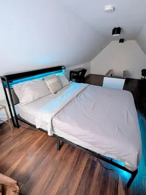 a large bed in a room with a wooden floor at 4 Bedroom Luxury House, Free Parking, Next to LRT, Kitchener Downtown, near Chicopee Ski Club in Kitchener