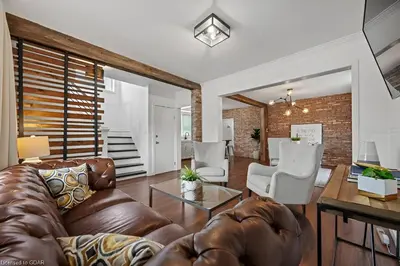 a living room with a leather couch and chairs at 4 Bedroom Luxury House, Free Parking, Next to LRT, Kitchener Downtown, near Chicopee Ski Club in Kitchener