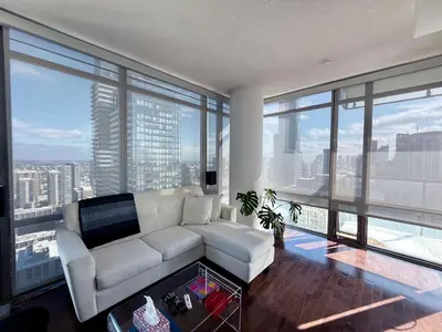 a living room with a white couch and large windows at 44th Floor, Panoramic Views, Bay Corridor Downtown Toronto Condo in Toronto