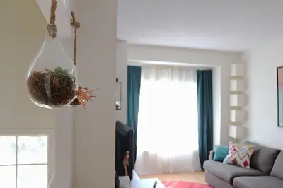 a living room with a couch and a hanging plant at LakePark Artsy 3 bedroom Townhouse 1 Parking in Toronto