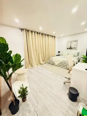 a bedroom with a bed and a plant in it at Cozy private backyard garden studio in Pickering