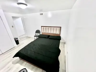 a bedroom with a black bed in a white room at Private Room Near Airport D7 in Brampton
