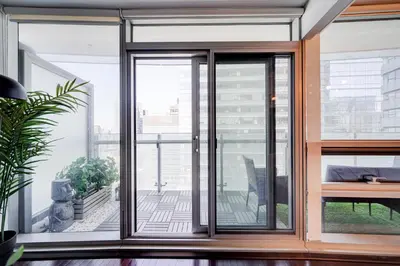 an open glass door in a room with a balcony at The Urban Escape in Toronto