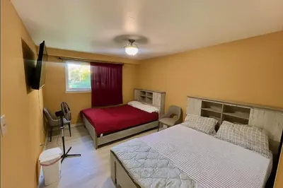 a bedroom with two beds and a television in it at Private Room Near Airport D2 in Brampton