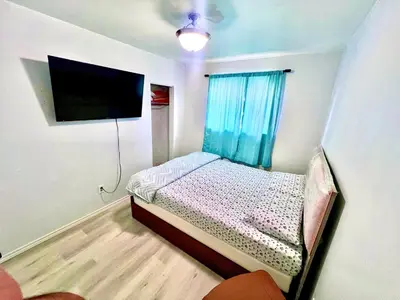 a small bedroom with a bed and a flat screen tv at D3 Room Near Airport in Brampton